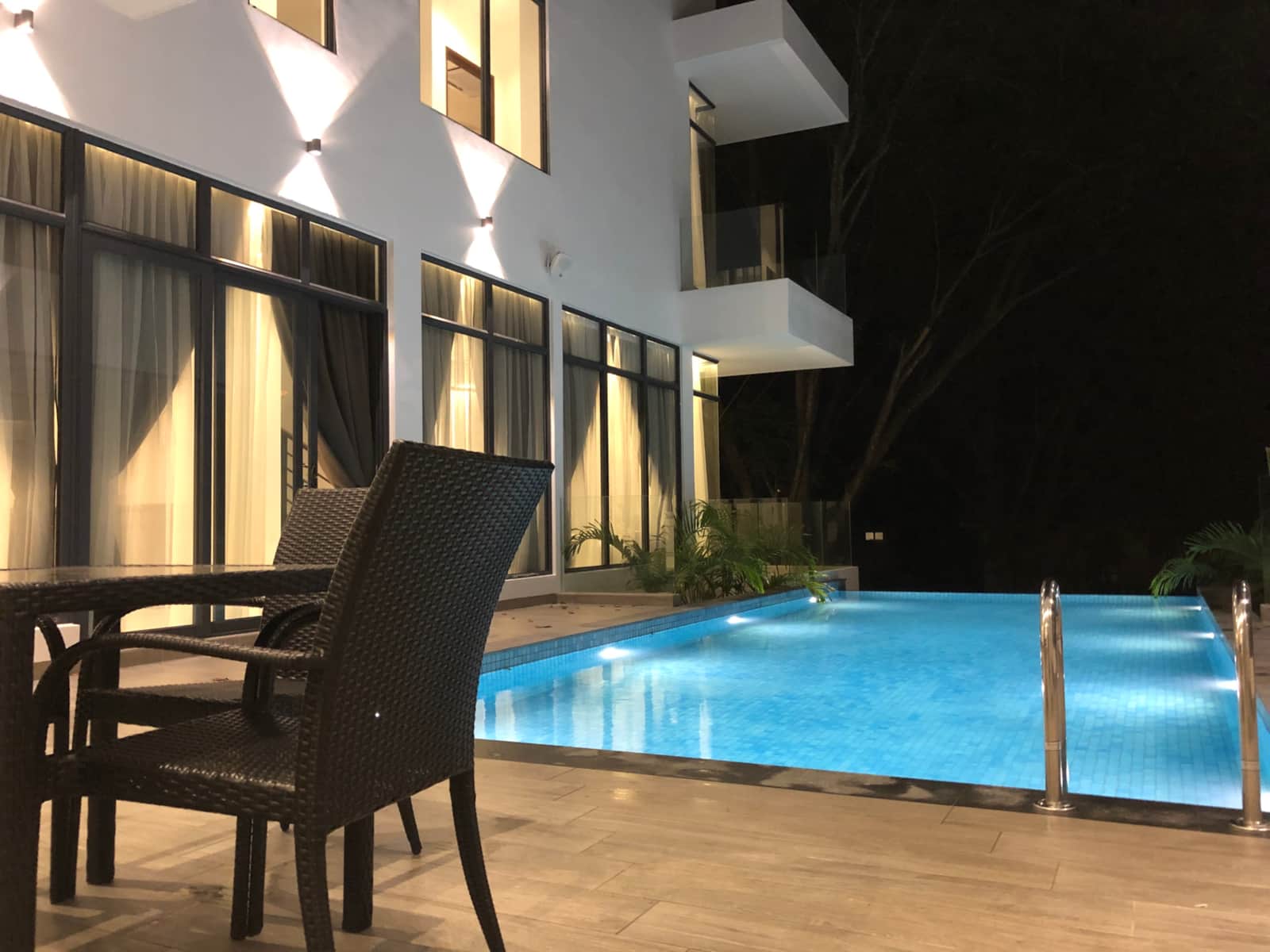 Poolside seating beside the lit infinity pool
